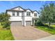 Attractive two-story home with well-maintained landscaping and a spacious brick driveway, offering a welcoming appeal at 3184 Pinenut Dr, Apopka, FL 32712