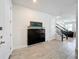 Hallway features tile flooring, a black cabinet with painting, and a staircase leading to the upper level at 3184 Pinenut Dr, Apopka, FL 32712