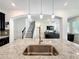Open-concept kitchen showcasing granite countertops, a stainless steel faucet, and views of the staircase at 3184 Pinenut Dr, Apopka, FL 32712