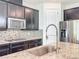 Modern kitchen with stainless steel appliances, mosaic backsplash, and granite countertops at 3184 Pinenut Dr, Apopka, FL 32712