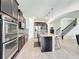Contemporary kitchen with stainless steel appliances, a central island, and a staircase nearby at 3184 Pinenut Dr, Apopka, FL 32712