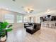 Inviting living room featuring tile floors, sectional sofa, and an open layout leading to the kitchen at 3184 Pinenut Dr, Apopka, FL 32712