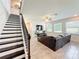 Bright living room featuring a dark-stained staircase and black metal railing at 3184 Pinenut Dr, Apopka, FL 32712