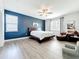 Inviting main bedroom with blue accent wall, sitting area, and plush bedding for a cozy retreat at 3184 Pinenut Dr, Apopka, FL 32712