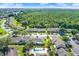 A lush aerial view of residences surrounded by trees, with a communal pool, and ample parking available to residents at 3249 Sandy Shore Ln, Kissimmee, FL 34743