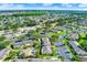 A sunny aerial view of the residences with a communal pool, parking, and the neighborhood surrounded by trees at 3249 Sandy Shore Ln, Kissimmee, FL 34743