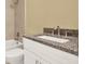 Well-appointed bathroom with a granite countertop, white vanity, and tiled shower and tub combination at 3249 Sandy Shore Ln, Kissimmee, FL 34743