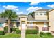 Charming townhome featuring manicured landscaping, a decorative fence, and a welcoming entryway at 3249 Sandy Shore Ln, Kissimmee, FL 34743