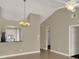 Bright living space with vaulted ceiling, stylish light fixture, and seamless flow to other areas of the home at 3249 Sandy Shore Ln, Kissimmee, FL 34743