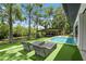 Inviting backyard featuring lounge chairs, manicured lawn, and scenic waterfront views at 33 Eastwind Ln, Maitland, FL 32751