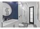 Stylish bathroom featuring a navy accent wall, glass shower, modern fixtures, and geometric tiling at 33 Eastwind Ln, Maitland, FL 32751