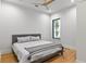 Minimalist bedroom with gray upholstered bed, hardwood floors, and a window with nature views at 33 Eastwind Ln, Maitland, FL 32751