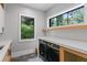 Modern laundry room with front-load machines, large window, bright countertop, and stylish hexagonal tile floor at 33 Eastwind Ln, Maitland, FL 32751