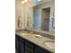Bathroom featuring dual sinks, granite countertops, and a large mirror at 3371 Yellowtop Loop, Clermont, FL 34714