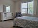 Bright bedroom featuring a large window, comfortable bed, dresser, and chair at 3371 Yellowtop Loop, Clermont, FL 34714