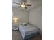 Comfortable bedroom with a ceiling fan, side table, and a patterned comforter at 3371 Yellowtop Loop, Clermont, FL 34714