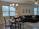 Open dining area with a glass-top table, modern chandelier, and views of the living room at 3371 Yellowtop Loop, Clermont, FL 34714
