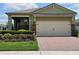 Charming single-Gathering home featuring a two-car garage, brick accents and tidy landscaping at 3371 Yellowtop Loop, Clermont, FL 34714