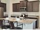 Modern kitchen featuring dark wood cabinets, granite countertops, and stainless steel appliances at 3371 Yellowtop Loop, Clermont, FL 34714