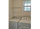 Functional laundry room with a window for natural light and a washer and dryer at 3371 Yellowtop Loop, Clermont, FL 34714