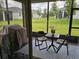 View of the backyard from the enclosed porch, which features a table, chairs, and grill at 3371 Yellowtop Loop, Clermont, FL 34714