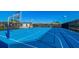 A full basketball court with a vibrant blue surface, net fencing, and clear blue skies at 3715 Lana Ave, Davenport, FL 33897