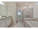 A modern bathroom with a soaking tub, a glass-enclosed shower, and a vanity with granite countertops at 3715 Lana Ave, Davenport, FL 33897