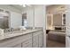 Bright bathroom featuring double sinks with granite countertops, white cabinetry, and a view to a bedroom at 3715 Lana Ave, Davenport, FL 33897