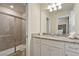 Well-lit bathroom featuring a granite countertop vanity and a tiled shower with a glass door at 3715 Lana Ave, Davenport, FL 33897