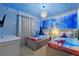 Themed bedroom with two twin beds, blue walls, mural art, carpeted floors, and unique lighting at 3715 Lana Ave, Davenport, FL 33897