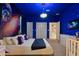 A unique bedroom features space-themed wall art, a comfortable bed, and stylish decor with plenty of space at 3715 Lana Ave, Davenport, FL 33897
