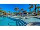 Resort-style community pool with plenty of lounge chairs and tropical landscaping at 3715 Lana Ave, Davenport, FL 33897