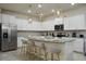 A modern kitchen featuring white cabinets, stainless steel appliances, granite countertops, and a center island with bar stool seating at 3715 Lana Ave, Davenport, FL 33897