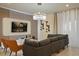 A modern living room boasts stylish decor, including a large sectional sofa, a chic chandelier, and an entertainment center at 3715 Lana Ave, Davenport, FL 33897