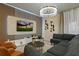 The cozy living room features a large sectional sofa, a stylish chandelier, and entertainment center with a TV at 3715 Lana Ave, Davenport, FL 33897