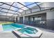 The screened in pool and spa feature backyard privacy and a brick patio at 3715 Lana Ave, Davenport, FL 33897