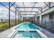 A screened in pool and spa are surrounded by a brick patio and fence at 3715 Lana Ave, Davenport, FL 33897