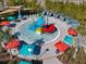 Aerial view of the community splash pad featuring a vibrant play structure and sun umbrellas at 3715 Lana Ave, Davenport, FL 33897
