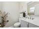 Cozy half bathroom features a toilet, sink with gray vanity, shelf, and a round mirror at 3816 Tram Ct, Orlando, FL 32810
