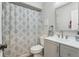 Bathroom with shower featuring a patterned shower curtain, toilet, vanity with sink, and framed mirror at 3816 Tram Ct, Orlando, FL 32810