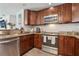 Kitchen featuring wooden cabinets, granite countertops, and stainless steel appliances at 3816 Tram Ct, Orlando, FL 32810
