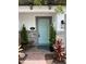 Charming facade featuring a light blue front door, brick accents, and decorative plants, creating a welcoming entrance at 391 Cape Honeysuckle Pl, Sanford, FL 32771