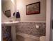 Stylish half bathroom with decorative wallpaper and sleek pedestal sink at 391 Cape Honeysuckle Pl, Sanford, FL 32771