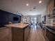 Spacious kitchen island with stainless steel appliances, complemented by modern wood flooring and adjacent dining area at 391 Cape Honeysuckle Pl, Sanford, FL 32771