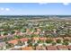 Expansive aerial view showcasing a neighborhood with lush landscaping, many single Gathering homes and beautiful scenery at 4080 Oaktree Dr, Davenport, FL 33837