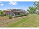 Lush backyard featuring a screened-in patio, perfect for outdoor relaxation at 4080 Oaktree Dr, Davenport, FL 33837
