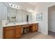 Bright bathroom featuring a double vanity, large mirror, and convenient makeup area with seating at 4080 Oaktree Dr, Davenport, FL 33837