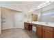 Accessible bathroom featuring a double vanity, large mirror, and tiled floor for easy maintenance at 4080 Oaktree Dr, Davenport, FL 33837