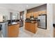 Spacious kitchen featuring stainless steel appliances, wooden cabinets, and a center island with granite countertops at 4080 Oaktree Dr, Davenport, FL 33837