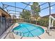 Sparkling screened-in pool with safety fence and lounge chairs in backyard at 4080 Oaktree Dr, Davenport, FL 33837